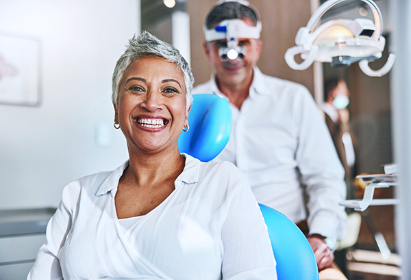 Portrait, happy and dental with a woman patient in a doctor office for oral hygiene or health. Smile, teeth and healthcare with a senior female sitting in a chair at the dentist for hygiene.